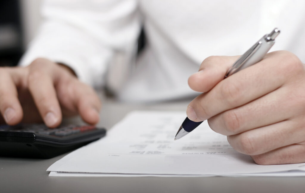 close up of a person doing a calculation with a calculator and pen